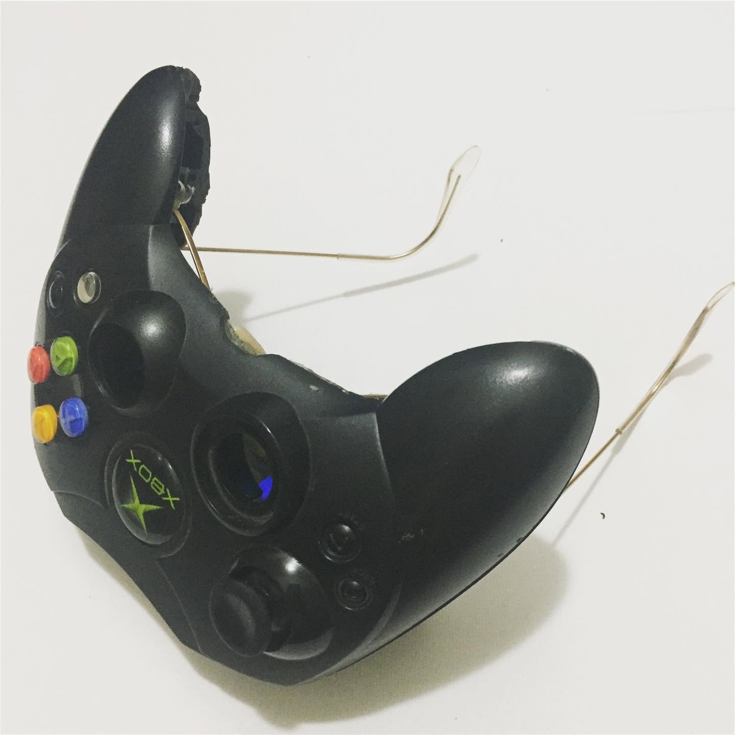 Angled white-background product photograph of black Xbox controller sunglasses