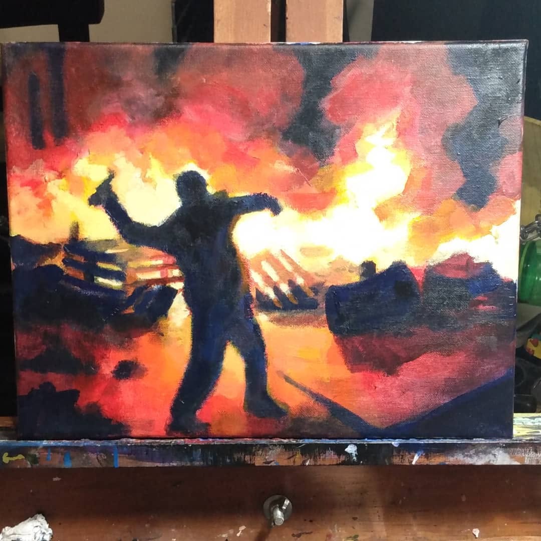 Silhouetted figure throwing a Molotov cocktail before burning cars