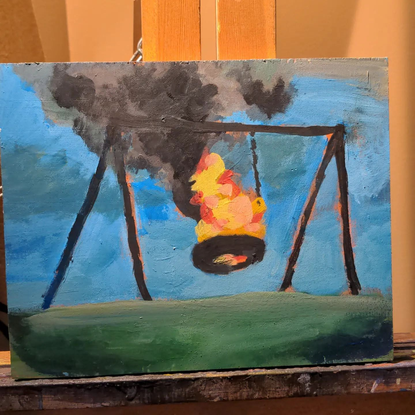 Painting of a tire swing engulfed in fire beneath dark smoke